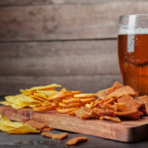 Lager beer and snacks on wooden table. Nuts, chips, pretzel Lager beer and snacks on wooden table. Nuts, chips, pretzel